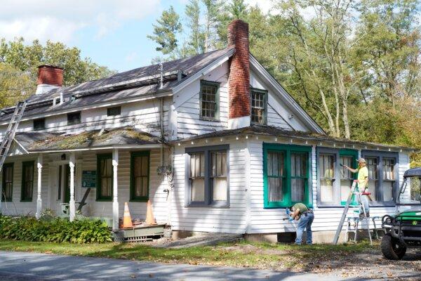 Robin Brennan and Alex Zemski paint the window frames of a historic house in D&H Canal Park in Cuddebackville, N.Y., on Oct. 3, 2024. (Cara Ding/The Epoch Times)