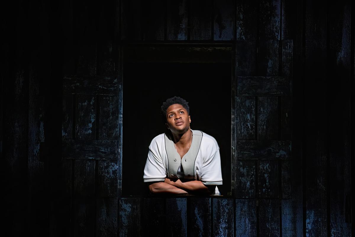 George Gibbs (Ephraim Sykes) is lost in thought as he peers through a window, in "Our Town." (Daniel Rader)