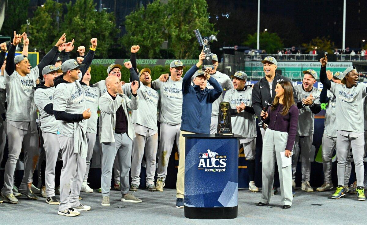 New York Yankees chairman Hal Steinbrenner hoists the trophy after the Yankees beat the Cleveland Guardians 5–2 in 10 innings in Game Five of the American League Championship Series at Progressive Field in Cleveland, Ohio on October 19, 2024. (Jason Miller/Getty Images)