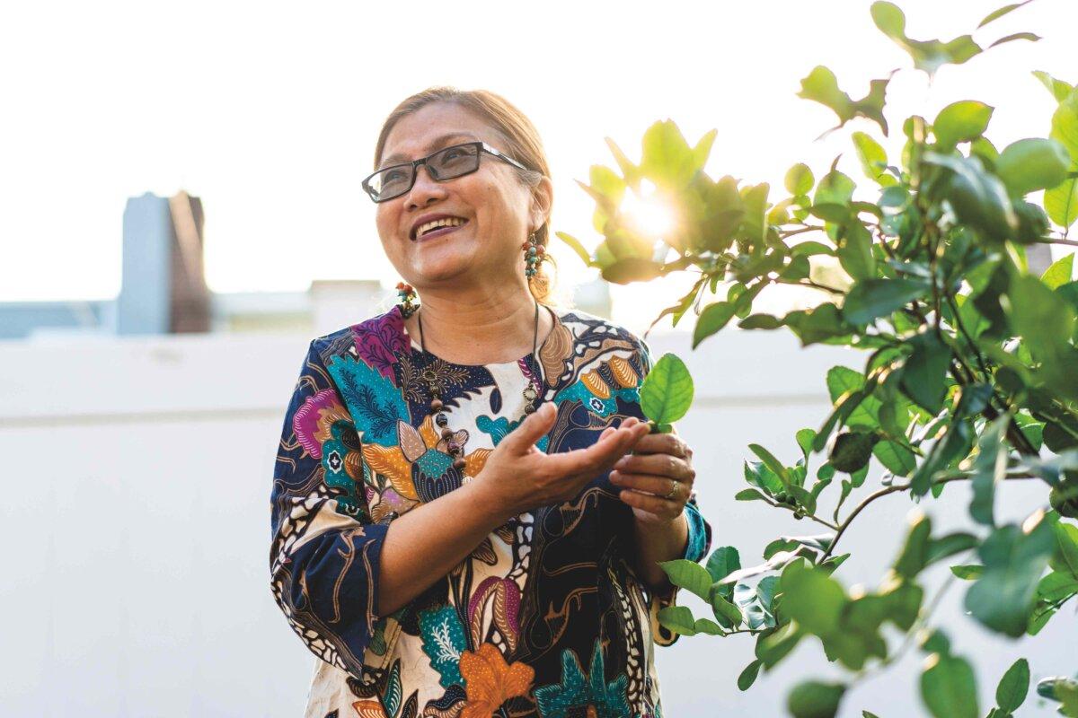 Woworuntu with one of her two backyard lime trees, from which she harvests both fragrant leaves and fruit. (Samira Bouaou for American Essence)