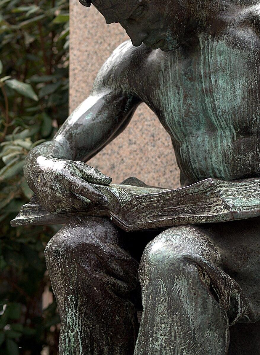 A close-up of "The Reading Blacksmith," 1904, by Daniel Chester French. This statue was created to commemorate Col. James Anderson, a Pittsburg industrialist who created free libraries for "working boys." Andrew Carnegie, who funded the monument, had been one of those boys. (Public Domain)
