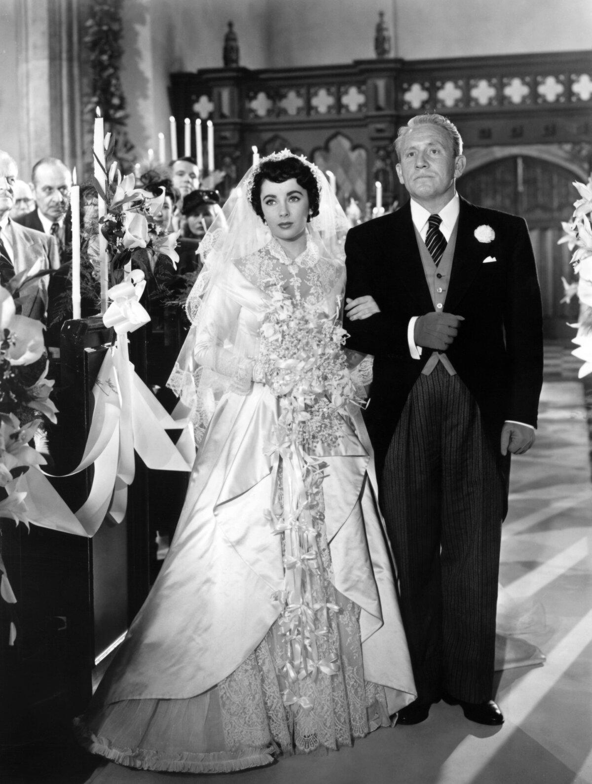 Father of the bride Stanley T. Banks (Spencer Tracy) takes his daughter (Elizabeth Taylor) down the aisle, in "Father of the Bride." (MovieStillsDB)