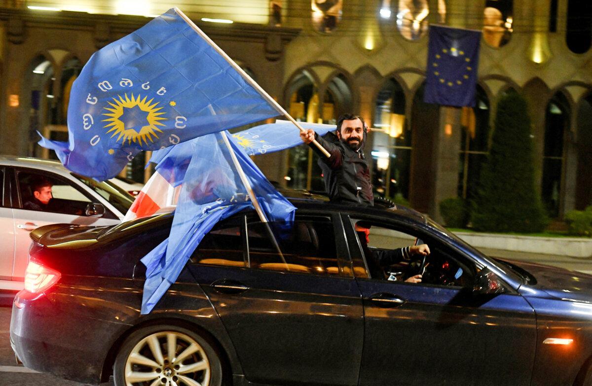 A supporter of the Georgian Dream party waves the party's flag after the announcement of results of parliamentary elections in Tbilisi, Georgia, on Oct. 26, 2024. (Zurab Javakhadze/Reuters)