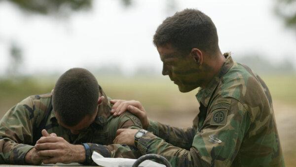 Former U.S. Army chaplain Jeff Struecker prays with a soldier. (Courtesy of Paulist Productions)