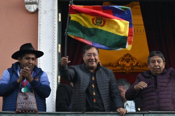Bolivian President Luis Arce (C) waves a Bolivian flag at the balcony of the Government Palace in La Paz on June 26, 2024. (Aizar Raldes/AFP)