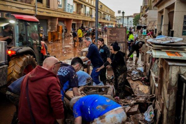 People clean their houses affected by floods in Utiel, Spain, on Oct. 30, 2024. (Manu Fernandez/AP Photo)