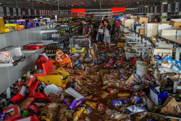 People pick up goods in a supermarket affected by the floods in Valencia, Spain, on Oct. 31, 2024. (Manu Fernandez/AP Photo)
