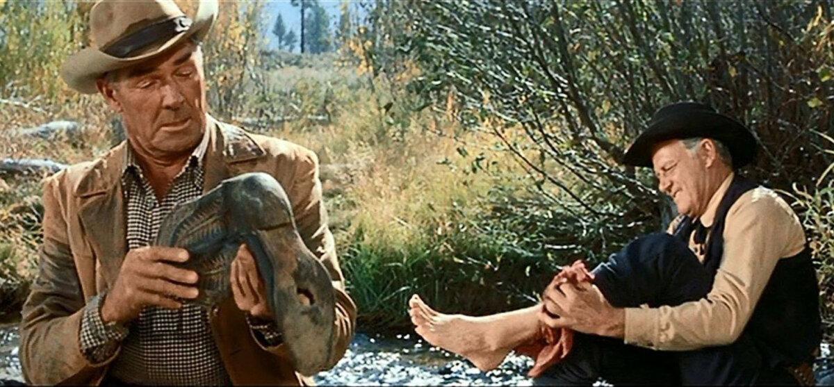Gil Westrum (Randolph Scott, L) examines Judd's (Joel McCrea) worn boot, in “Ride the High Country.” (MGM)