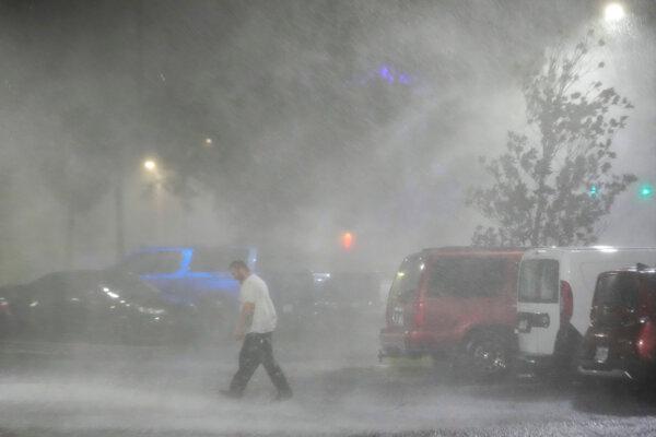Max Watts, of Buford, Ga., walks in the parking lot to check on a trailer parked outside the hotel where he is riding out Hurricane Milton with coworkers, in Tampa, Fla., on Oct. 9, 2024. (Julio Cortez/AP Photo)