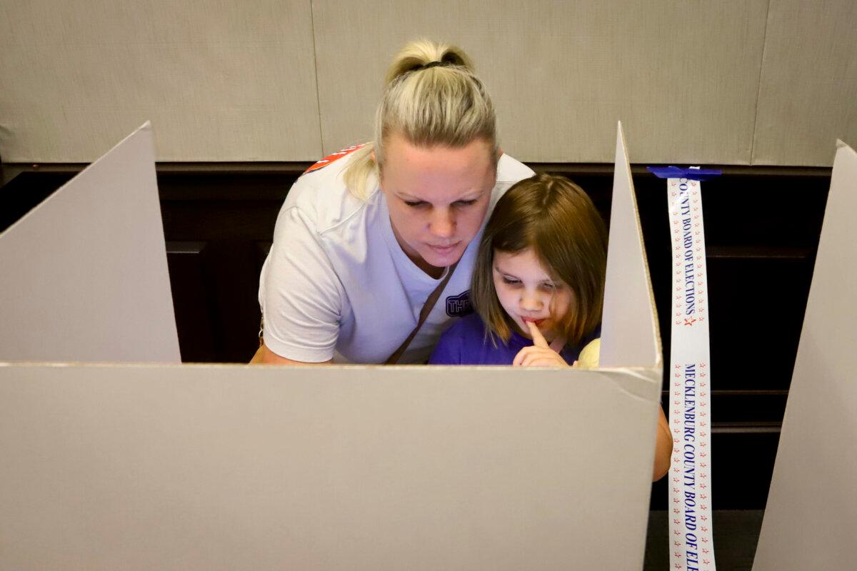 Chloe McDowell, 6, gets first-hand experience voting with her mother, Brittany McDowell, at the Mint Hill Town Hall precinct in Mint Hill, N.C., on Nov. 5, 2024. (Jennifer Podis for The Epoch Times)