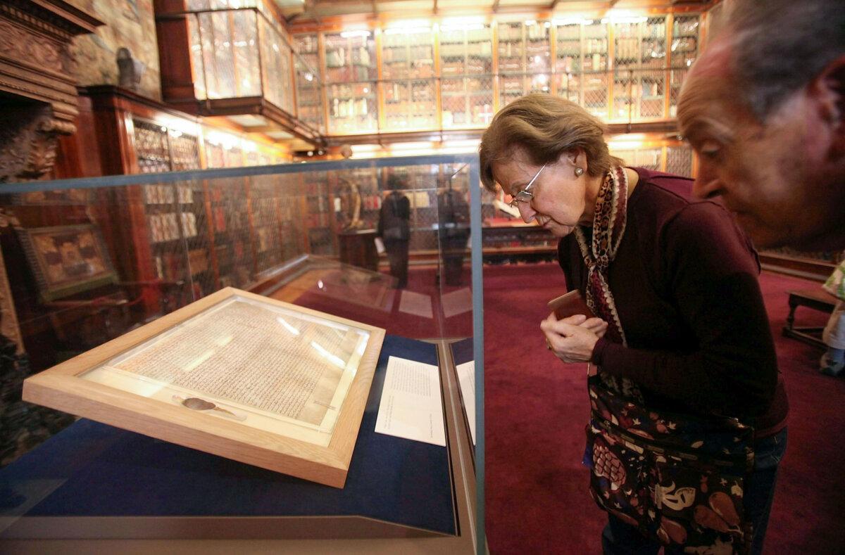 Visitors look at one of the earliest original manuscripts of the Magna Carta at the Morgan Library & Museum in New York in a file photo. (Mario Tama/Getty Images)