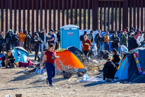 Migrants who passed through a gap in the United States border wall awaiting processing by Border Patrol agents in Jacumba, Calif., on Dec. 5, 2023. (John Fredricks/The Epoch Times)