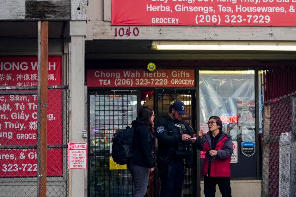 Police officers take a statement from a nearby business owner after multiple people were stabbed in the Chinatown-International District in Seattle on Nov. 8, 2024. (Lindsey Wasson/AP Photo)