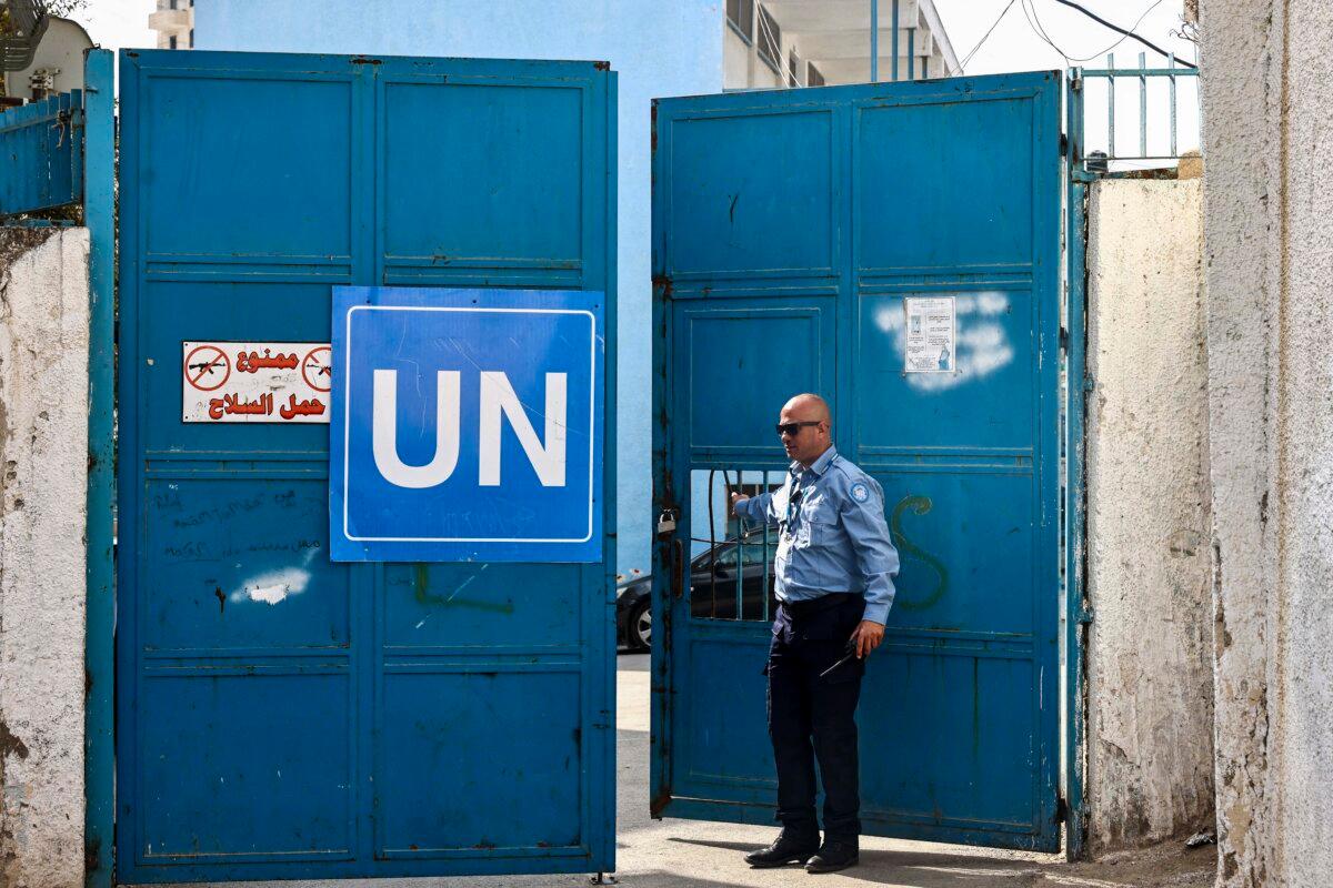 A guard opens the gate at a United Nations Relief and Works Agency for Palestine Refugees school in the Qalandia refugee camp in the West Bank, on Nov. 14, 2024. (Zain Jaafar/AFP via Getty Images)
