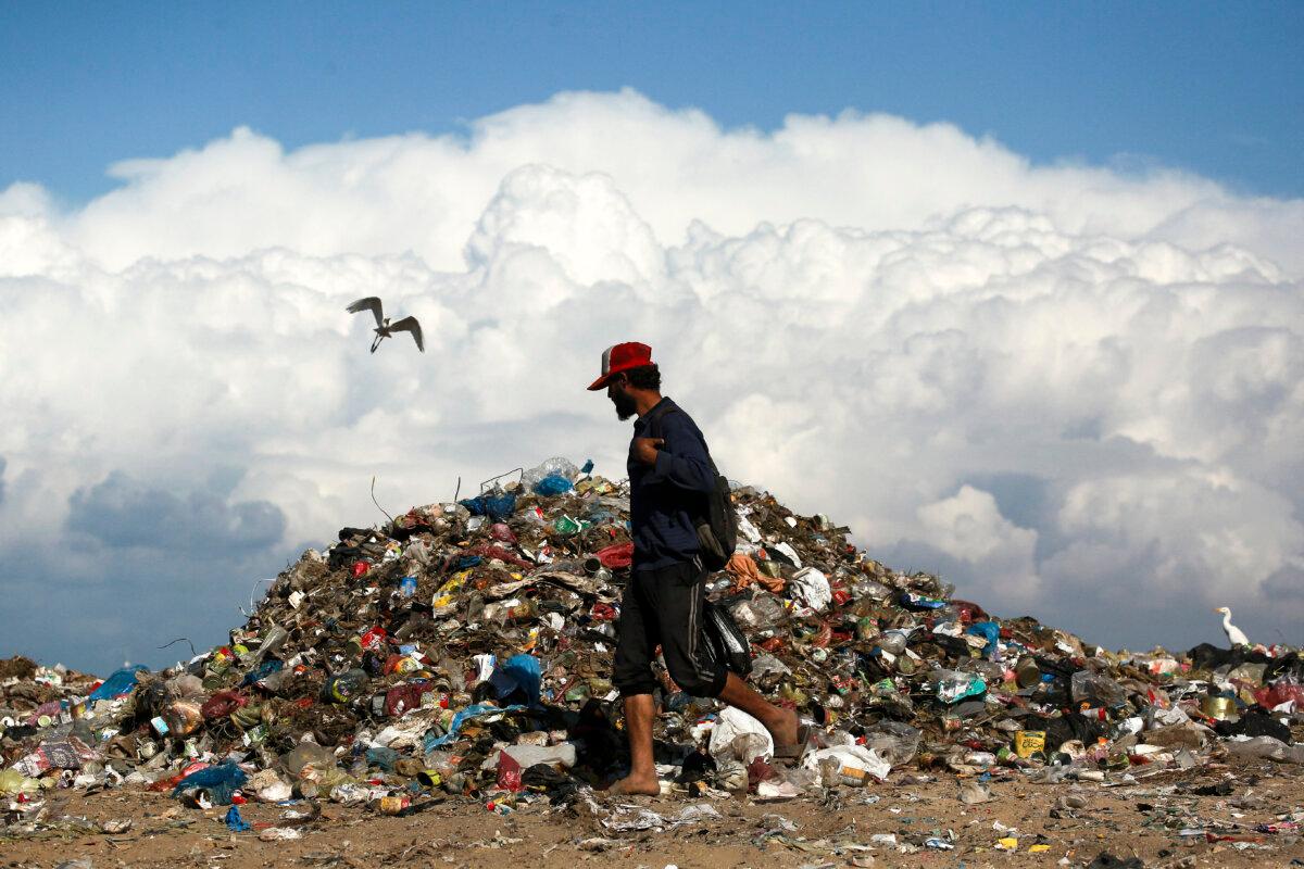 A man walks past a pile of garbage as he searches for useful things amid the Israel–Hamas war in the Gaza Strip, in Deir el Balah, in central Gaza, on Nov. 19, 2024. (Bashar Taleb/AFP via Getty Images)