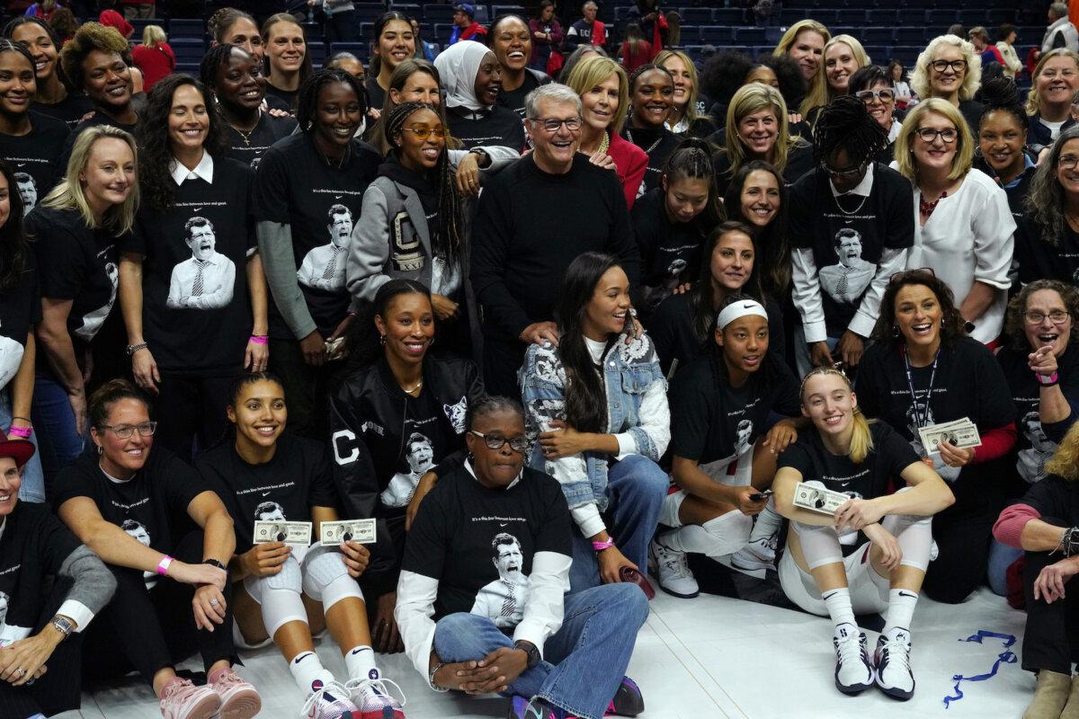 Connecticut Huskies head coach Geno Auriemma takes pictures with past and present players after becoming the NCAA all-time basketball wins leader at the Harry A. Gampel Pavilion in Storrs, Conn., on Nov. 20, 2024. (Joe Buglewicz/Getty Images)