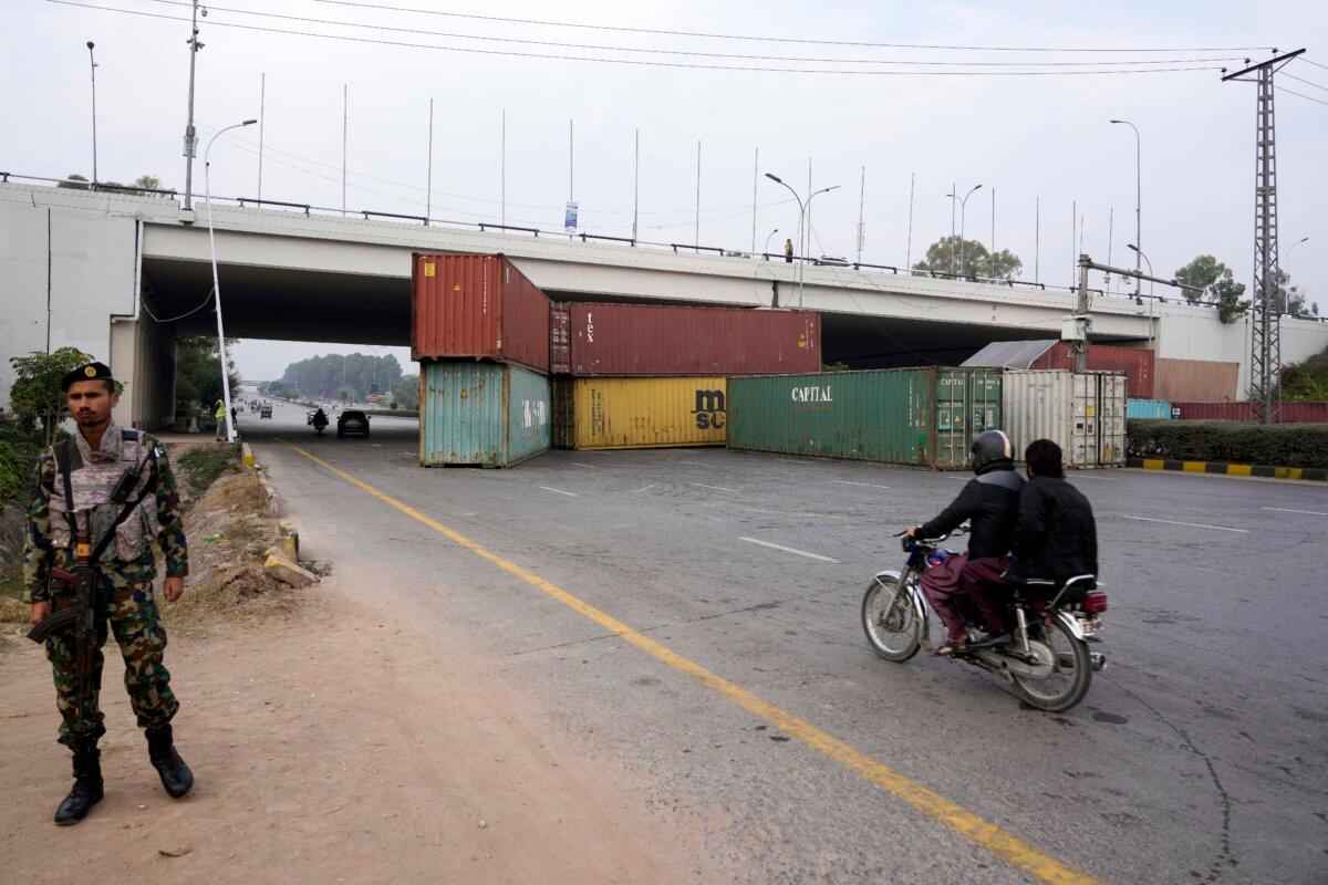 A soldier stands guard near a partially closed highway ahead of a planned rally by supporters of imprisoned former Prime Minister Imran Khan in Islamabad, Pakistan, on Nov. 23, 2024. (Anjum Naveed/AP Photo)