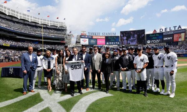 Long time radio broadcaster John Sterling poses for a photograph with family and members in the outfield at Yankee Stadium as he is honored prior to a game against the Tampa Bay Rays, in New York City on April 20, 2024. (Jim McIsaac/Getty Images)