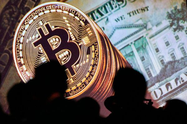 A graphical representation of Bitcoin and U.S. currencies are displayed on a screen as delegates listen to speakers during the Interpol World Congress in Singapore on July 4, 2017. (Dominic Gwinn/AFP via Getty Images)