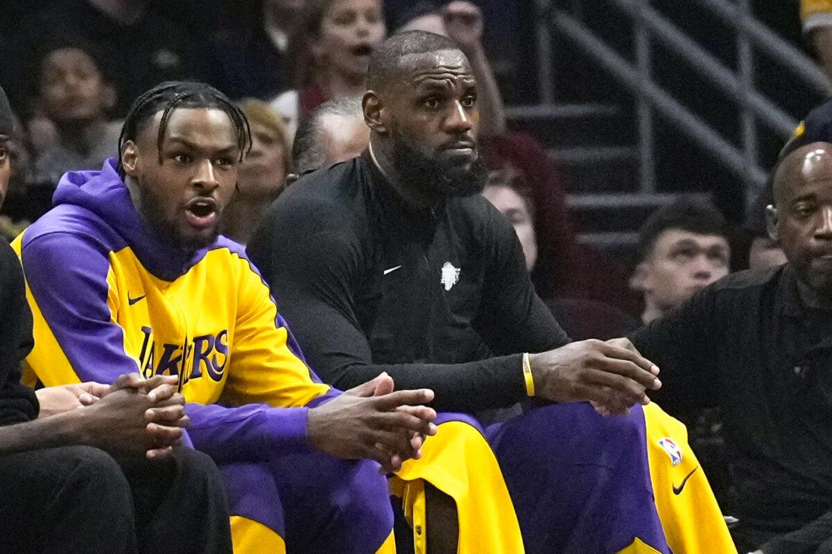 Los Angeles Lakers guard Bronny James (L) and forward LeBron James watch from the bench in the first half of a game against the Cleveland Cavaliers in Cleveland on Oct. 30, 2024. (Sue Ogrocki/AP Photo)
