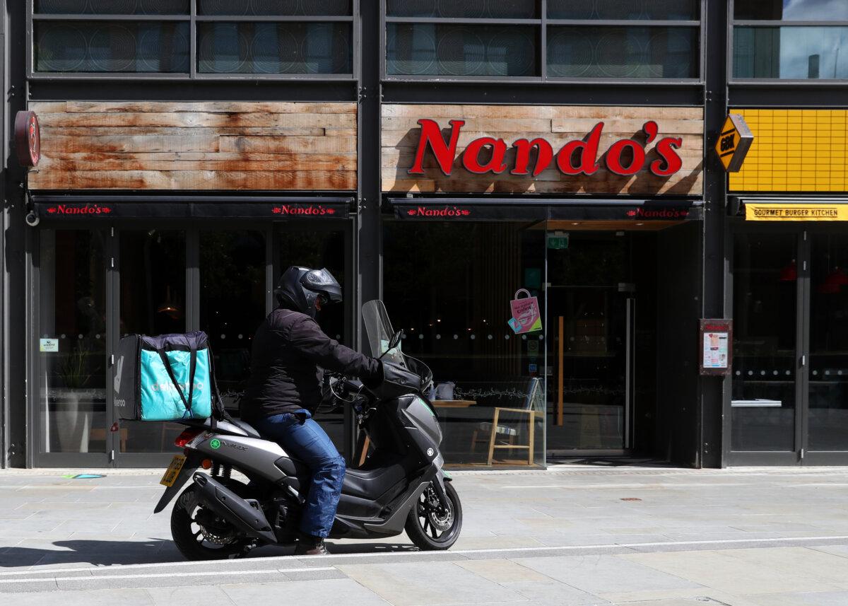 A Deliveroo driver collects a takeaway order from Nando's in Aylesbury, England, on June 5, 2020. (Catherine Ivill/Getty Images)