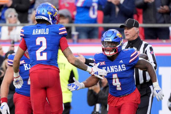 Kansas running back Devin Neal (4) celebrates with Kansas wide receiver Lawrence Arnold (2) after scoring a touchdown during the first half of a Nov. 23 game in Kansas City, Mo. (Charlie Riedel/AP Photo)