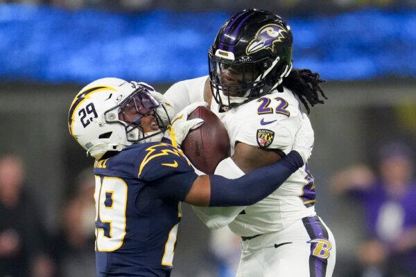 Baltimore Ravens running back Derrick Henry (22) is tackled by Los Angeles Chargers cornerback Tarheeb Still (29) during the second half of an NFL football game in Inglewood, Calif., on Nov. 25, 2024. (Eric Thayer/AP Photo)