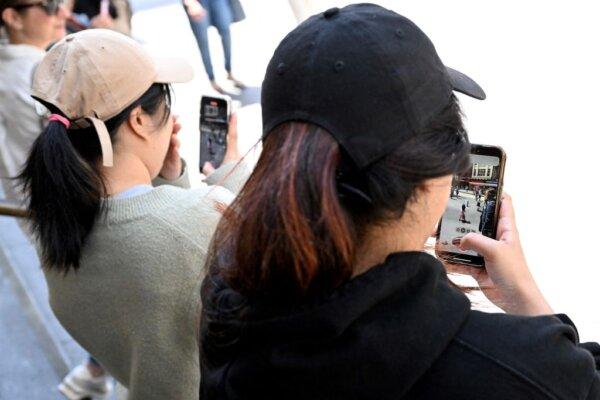 Young people look at their phones in Melbourne, Australia, on Nov. 28, 2024. (William West/AFP via Getty Images)