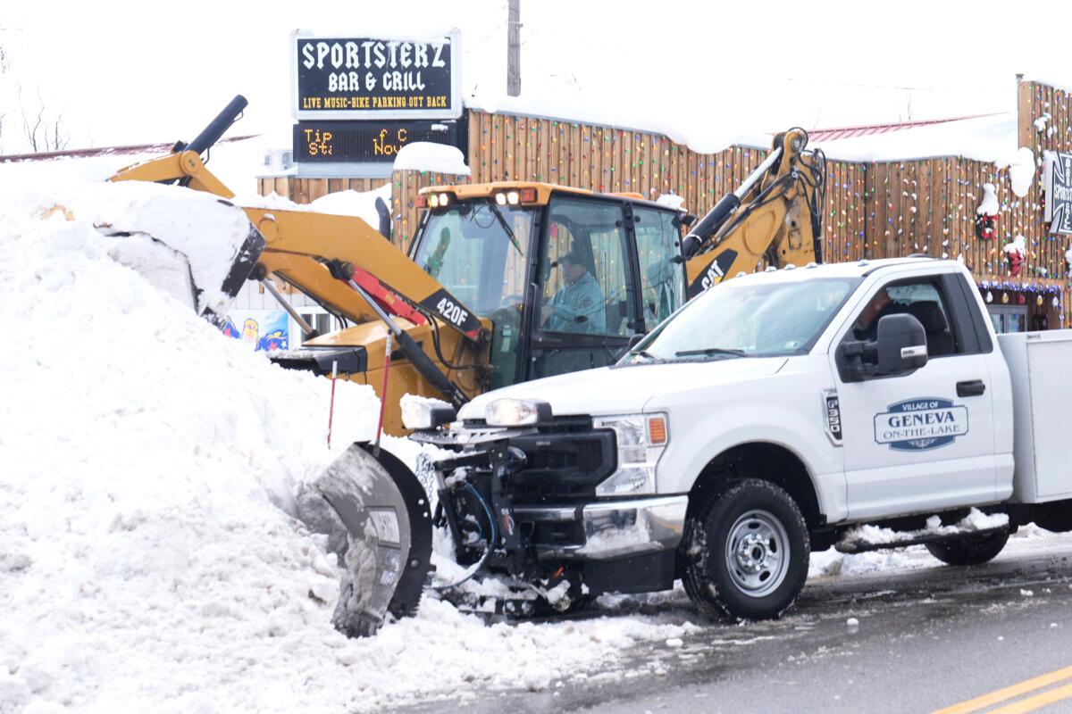 Dwayne Bennett, top, and Scott Stear, bottom, double team the snow to clear a road in Geneva-on-the-Lake, Ohio, on Dec. 2, 2024. (Sue Ogrocki/AP Photo)