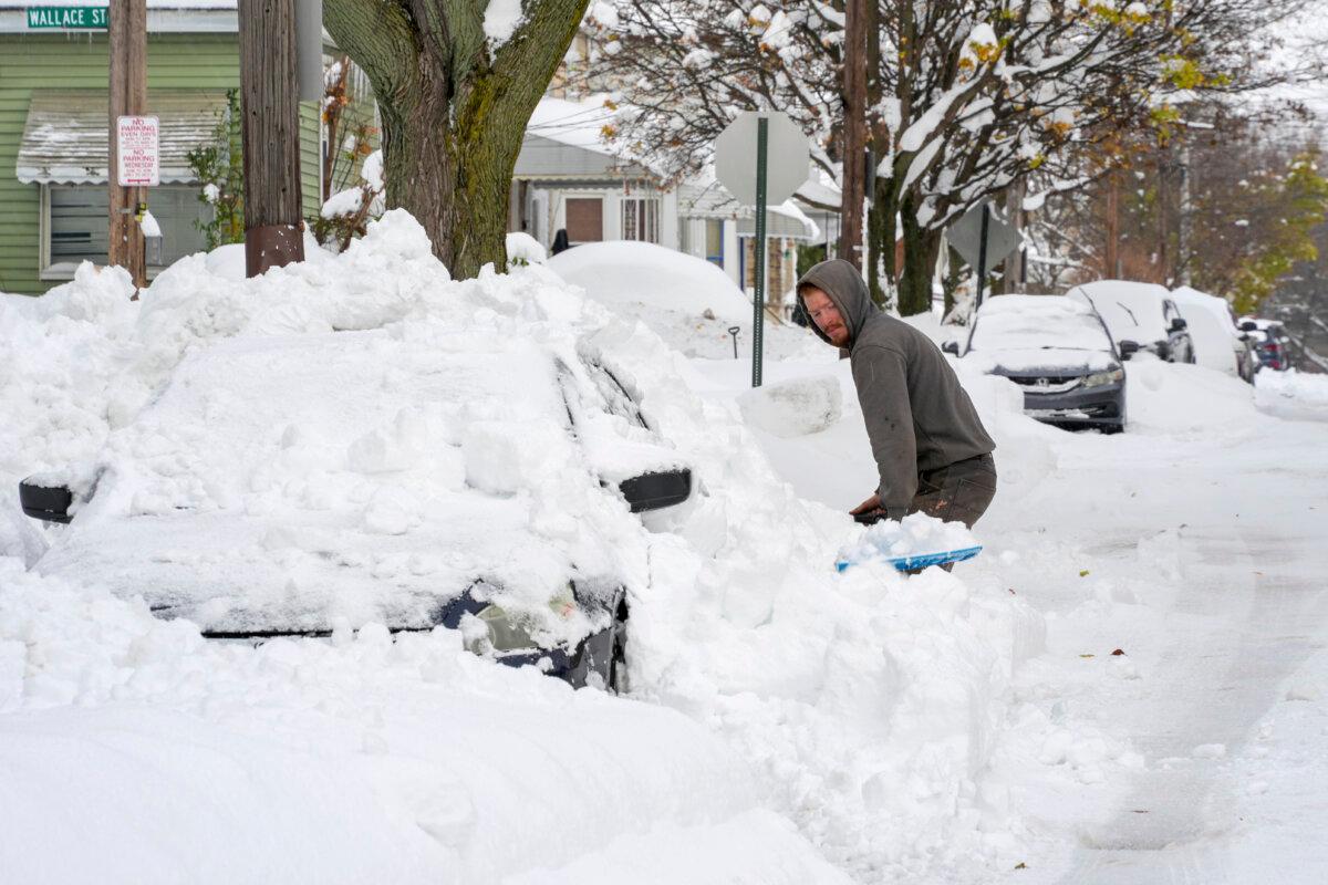 Matthew Jewell shovels snow off his father's car on a side street in Erie, Pa., on Dec 2, 2024. (Gene J. Puskar/AP Photo)