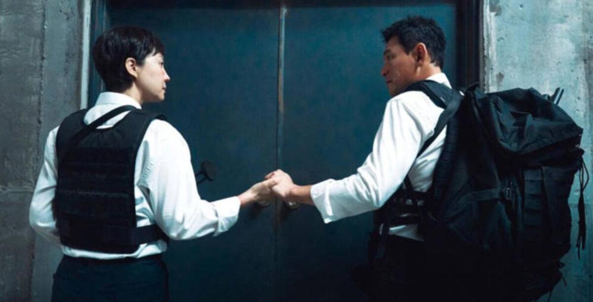 Kang Mi-seon (Yum Jung-ah), and Park Kang-moo (Hwang Jung-min) prepare for action, in “Mission: Cross.” (Netflix).
