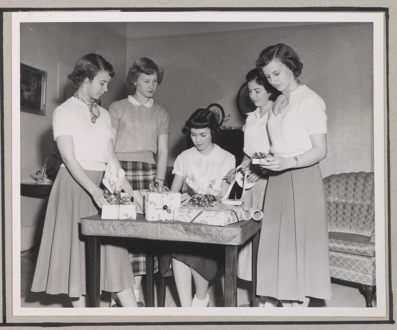 Young women wrap Christmas gifts at a club meeting in Clarkesville, Ga., in 1950. (Public Domain)