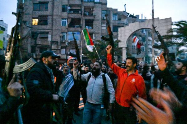 Local residents cheer as they gather on a street in the Damascus, Syria, suburb of Jaramana on Dec. 8, 2024. (Louai Beshara/AFP via Getty Images)