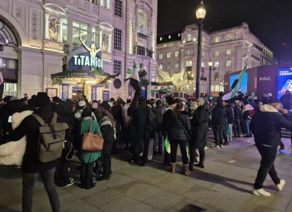 A group of Syrians wave the country's new flag while celebrating the fall of the Assad regime in Piccadilly Circus, London, on Dec. 9, 2024. (Chris Summers/The Epoch Times)