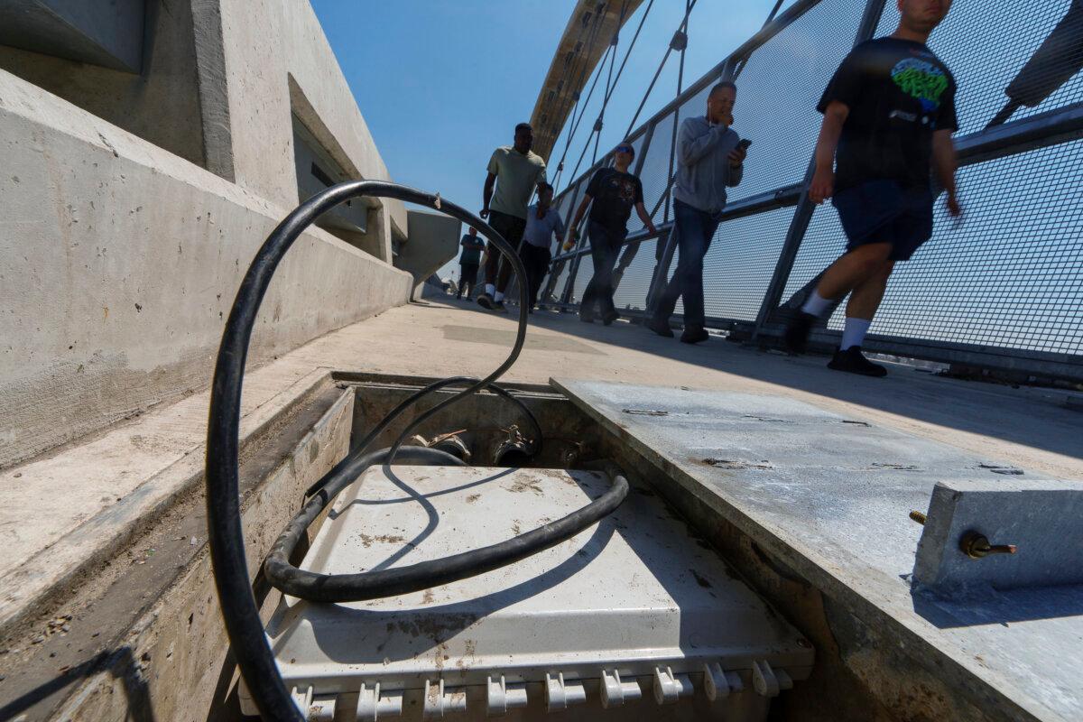 Pedestrians pass a vandalized high-voltage electric box on the 6th Street Viaduct in Los Angeles, on aug. 27, 2024. (The Canadian Press/AP-Damian Dovarganes)