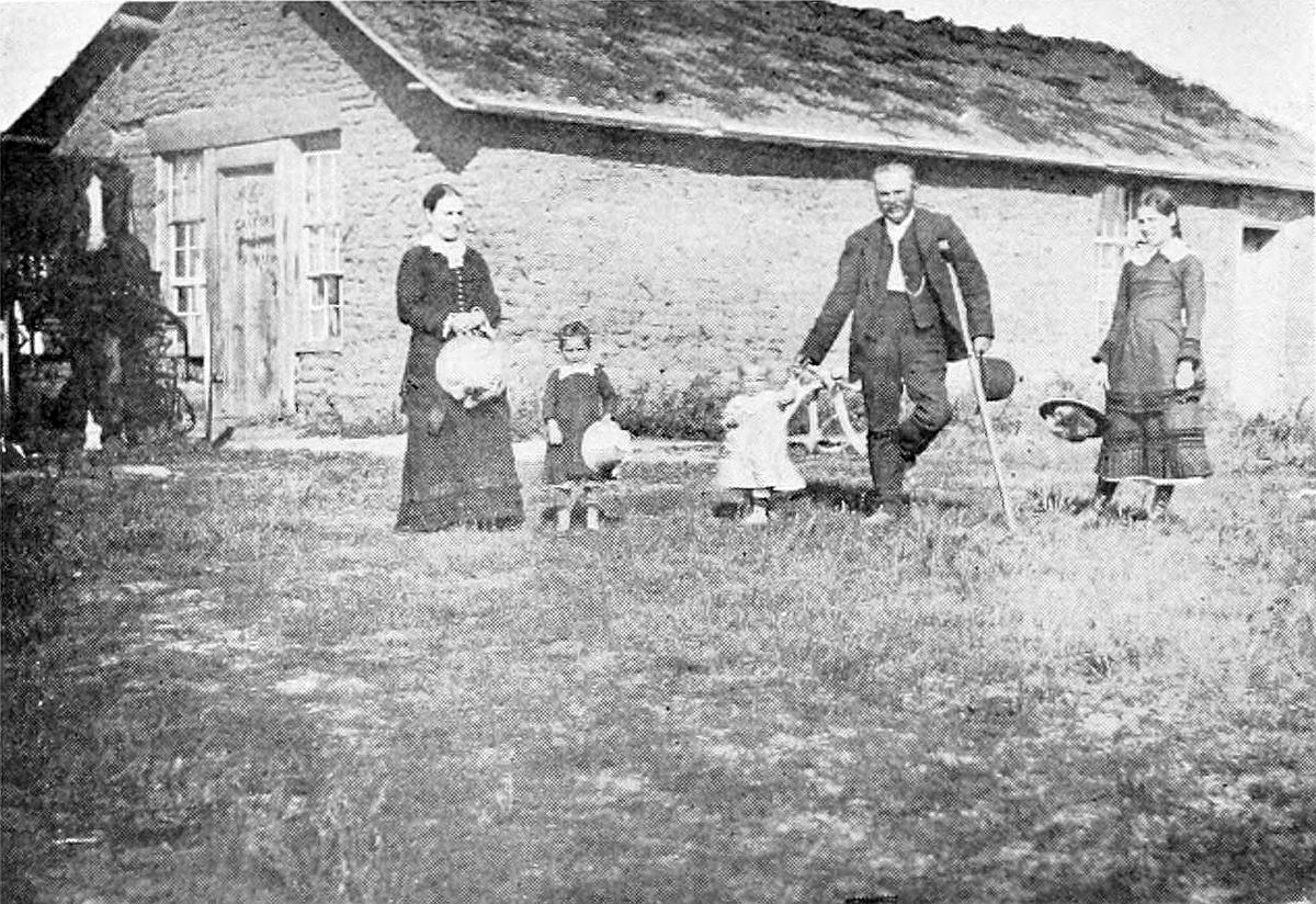 A pioneer family poses in 1901 outside the first store and hotel in Broken Bow, Neb. (Public Domain)