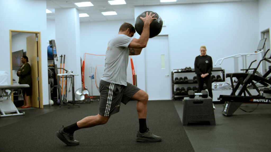 Aaron Rodgers with a medicine ball during a therapy workout, in "Aaron Rodgers: Enigma." (Netflix)