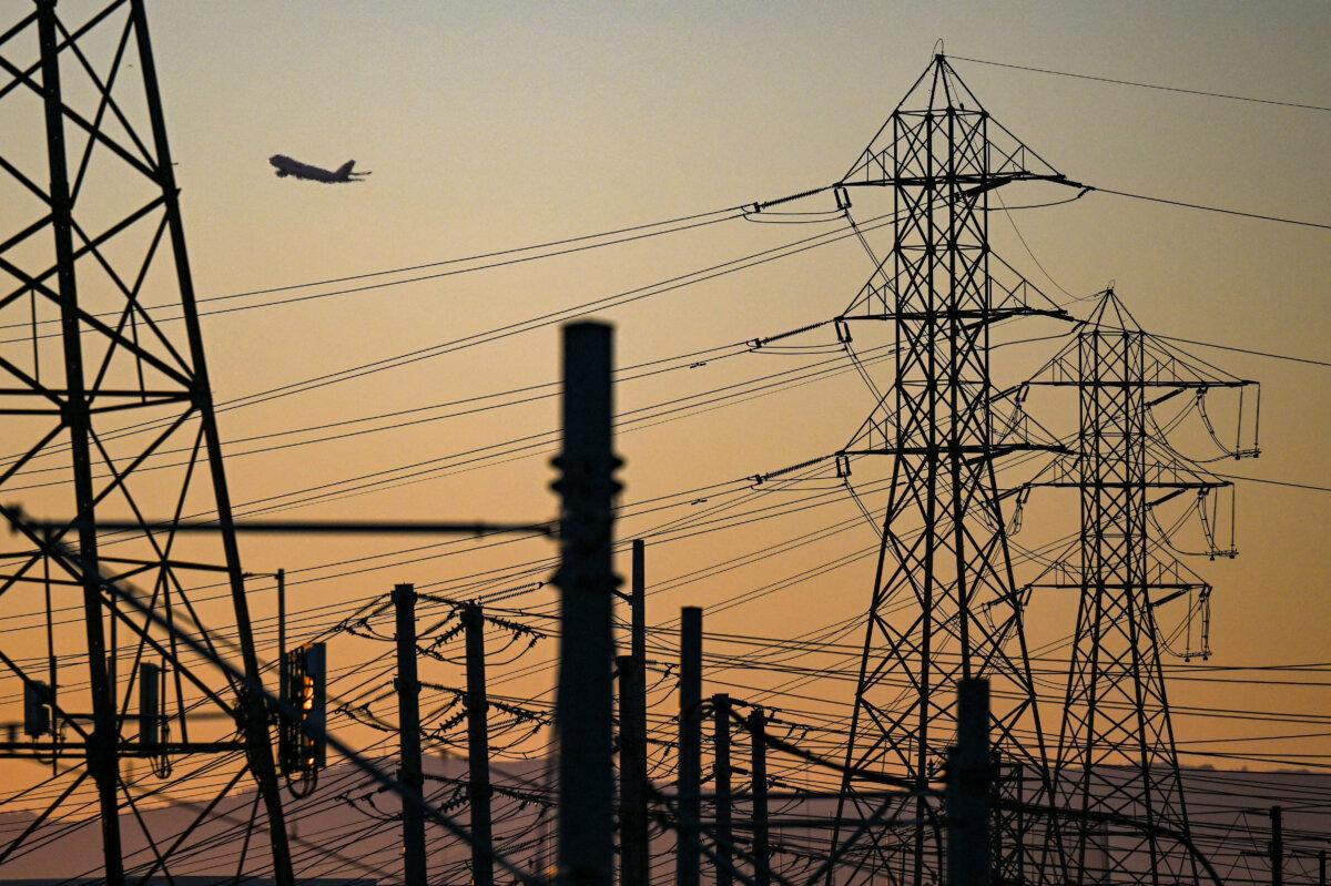 An aircraft takes off from Los Angeles International Airport behind power lines in El Segundo, Calif., on Aug. 31, 2022. (Patrick T. Fallon/AFP via Getty Images)