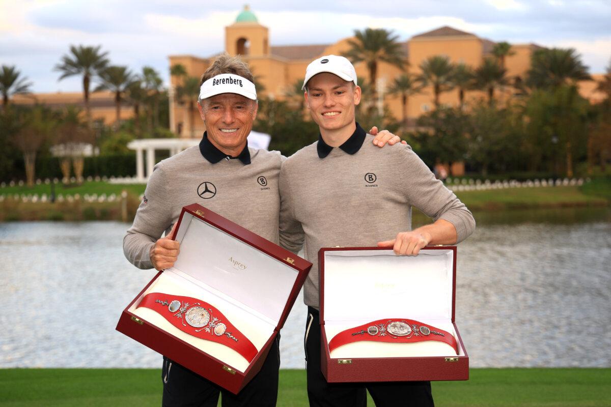 Bernhard Langer of Germany and his son Jason Langer pose with their trophies on the 18th green after putting in to win in a sudden-death playoff during the second round of the PNC Championship at Ritz-Carlton Golf Club in Orlando, Fla., on Dec. 22, 2024. (Mike Ehrmann/Getty Images)