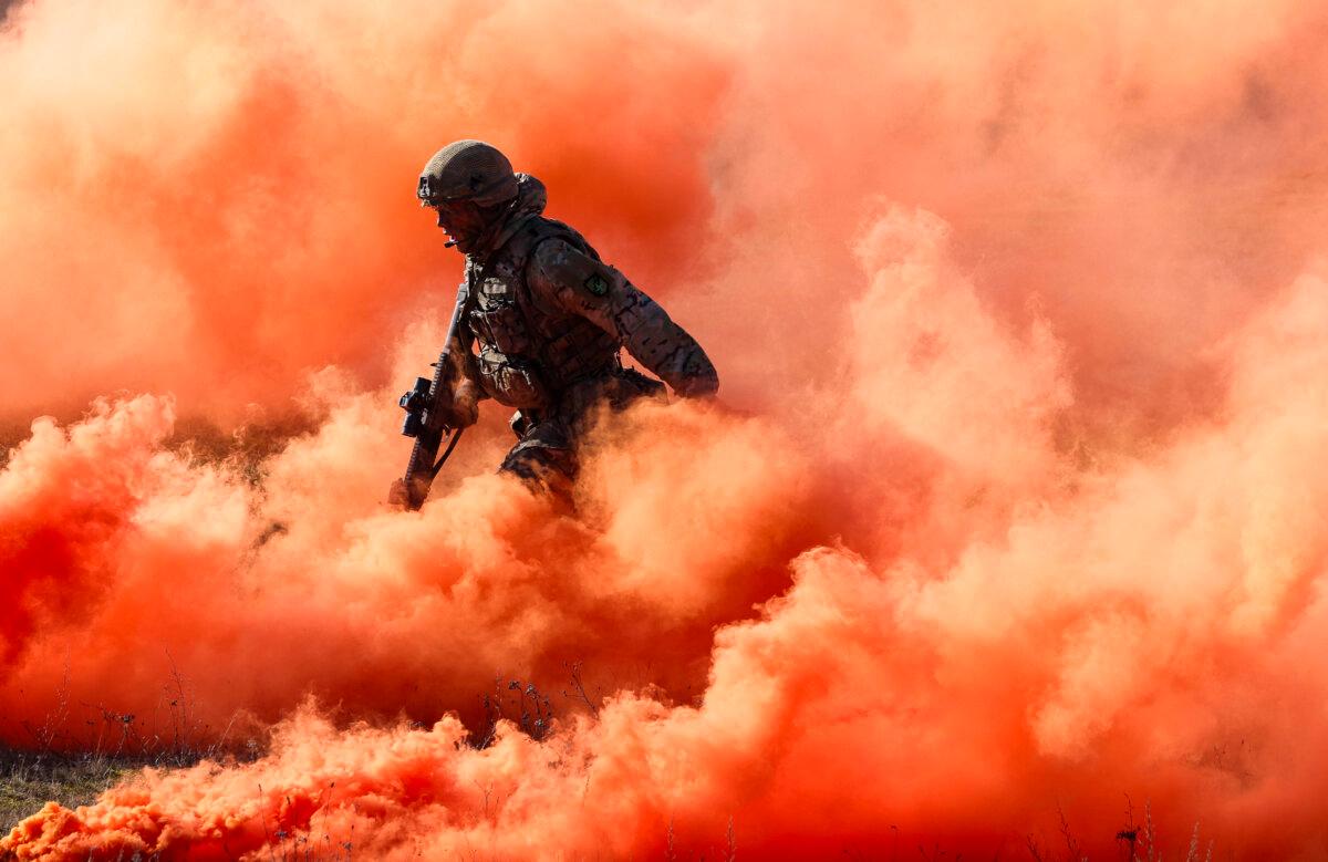 A soldier of the UK's 2nd Battalion Royal Anglian infantry unit storms an enemy position in a simulated attack during the NATO "Brilliant Jump" military exercises in Drawsko Pomorskie, Poland, on Feb. 26, 2024. (Sean Gallup/Getty Images)