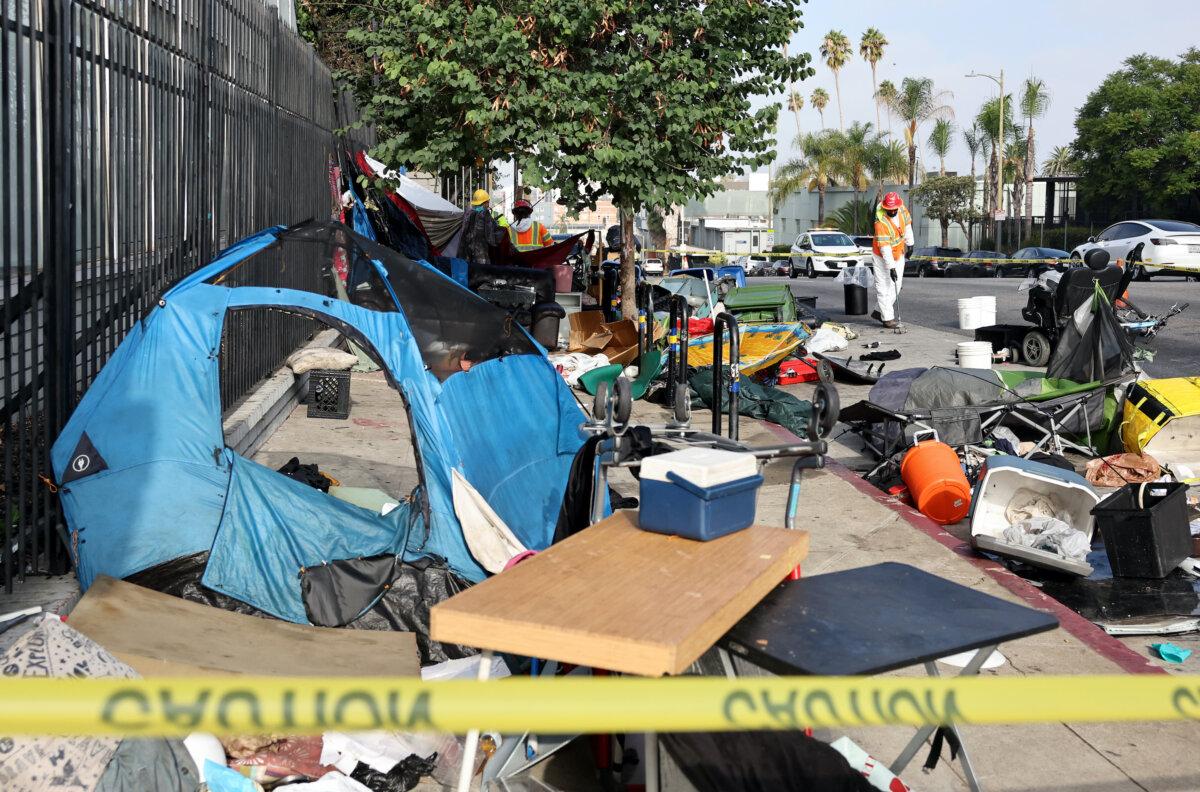 City sanitation workers clear an encampment as workers help bring unhoused people to interim housing, as part of an 'Inside Safe' operation, in Los Angeles on Sept. 26, 2024. (Mario Tama/Getty Images)
