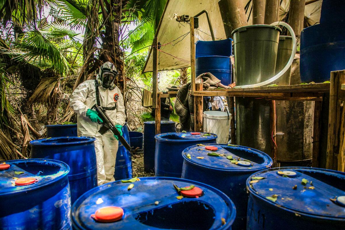 A Sinaloa state police officer helps dismantle one of three clandestine laboratories that produce illicit synthetic drugs, mainly methamphetamine, in El Dorado, Mexico, on June 4, 2019. (Rashide Frias/AFP via Getty Images)