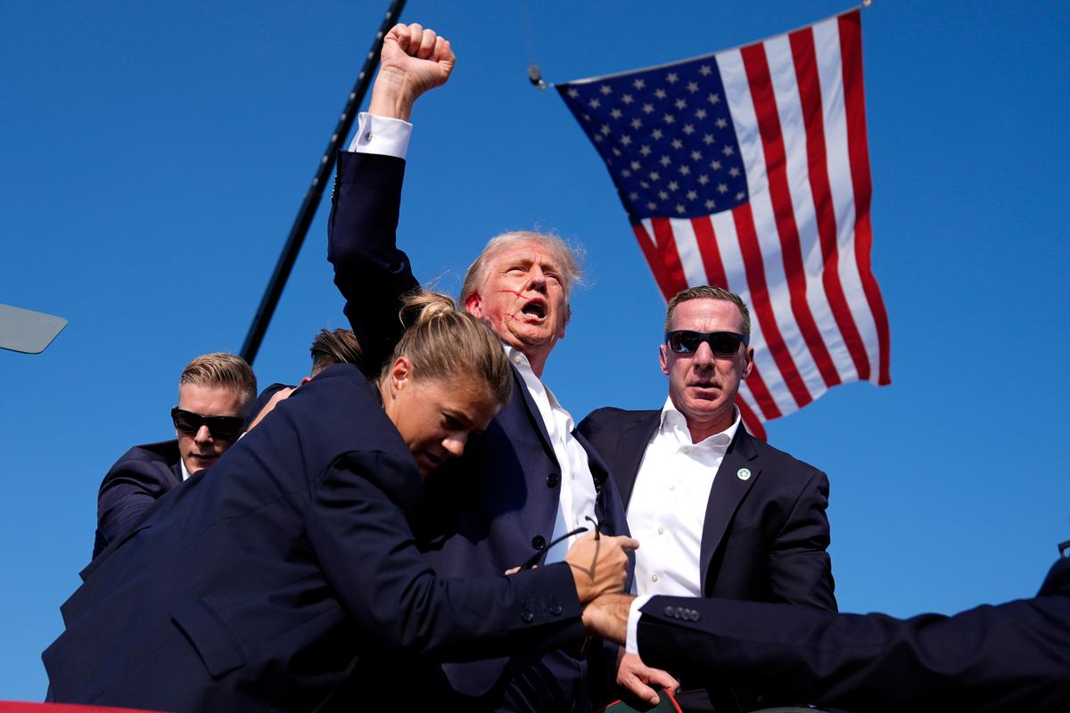 Then-Republican presidential candidate former President Donald Trump is surrounded by Secret Service agents after being shot at a campaign rally in Butler, Pa., on July 13, 2024. (Evan Vucci/AP Photo)