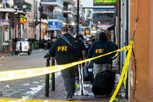 FBI investigators arrive at the scene where a white Ford F-150 pickup truck crashed into a work lift after allegedly driving into a crowd of New Year's revelers in the French Quarter of New Orleans, Louisiana, on Jan. 1, 2025. (Matthew Hinton/AFP via Getty Images)