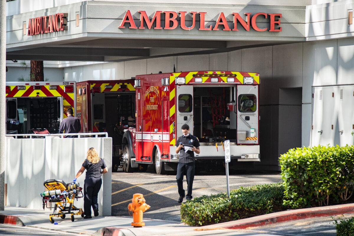 Healthcare workers work near an ambulance area of a hospital in Orange, Calif., on Aug. 9, 2021. (John Fredricks/The Epoch Times)