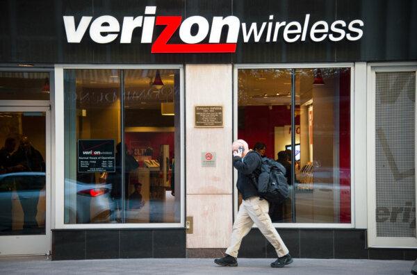 A man on his cell phone walks past a Verizon Wireless store in Washington on Dec. 30, 2014. (Jim Watson/AFP via Getty Images)