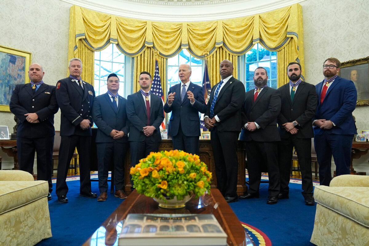 President Joe Biden (C) poses for a photo with Medal of Valor honorees in the Oval Office of the White House on Jan. 3, 2025. (LâR) Honorees are Lt. John Vanderstar of the New York City Fire Department, Firefighter Brendan Gaffney of the New York City Fire Department, Sgt. Tu Tran, of the Lincoln, Neb. Police Department, Det. Michael Collazo, of the Nashville, Tenn. Police Department, Chief John Drake, receiving on behalf of Officer Rex Engelbert, of the Nashville, Tenn. Police Department, Sgt. Jeffrey Mathes, of the Nashville, Tenn. Police Department, Det. Zachary Plese, of the Nashville, Tenn. Police Department, and Det. Ryan Cagle, of the Nashville, Tenn. Police Department. (Susan Walsh/AP Photo)