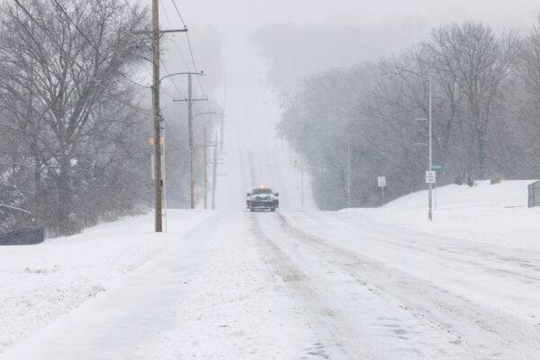A vehicle cautiously drives down a snowy road in Shawnee, Kan., on Jan. 5, 2025. (Chase Castor/Getty Images)