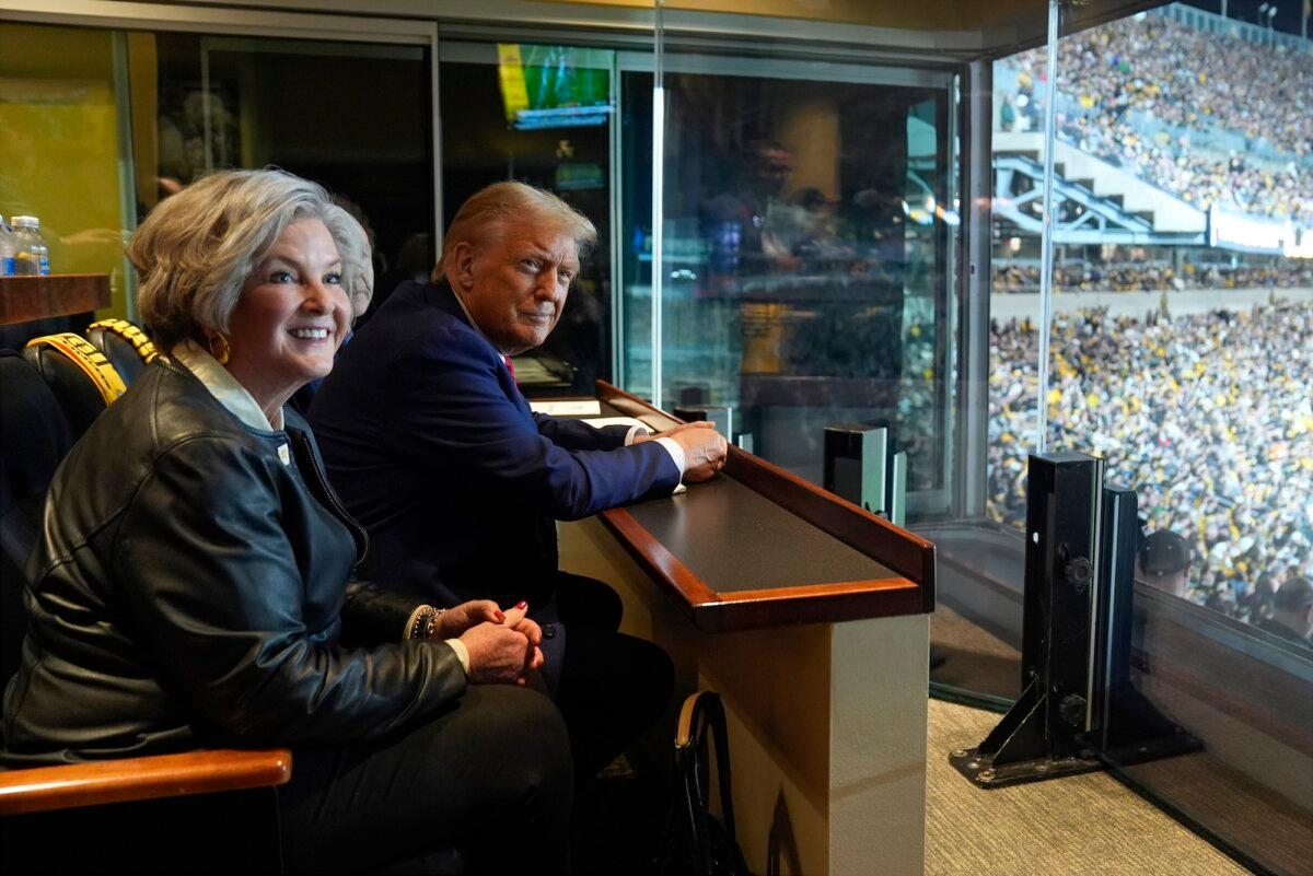 President Donald Trump sits with Susie Wiles as he attends a football game at Acrisure Stadium, in Pittsburgh, Pa., on Oct. 20, 2024. (AP Photo/Evan Vucci, Pool)