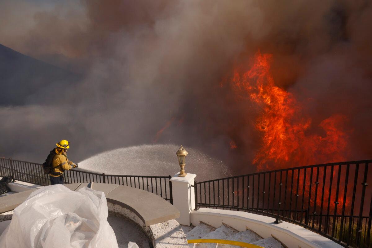 A firefighter makes a stand in front of the advancing Palisades Fire in the Pacific Palisades neighborhood of Los Angeles on Jan. 7, 2025. (Etienne Laurent/AP Photo)